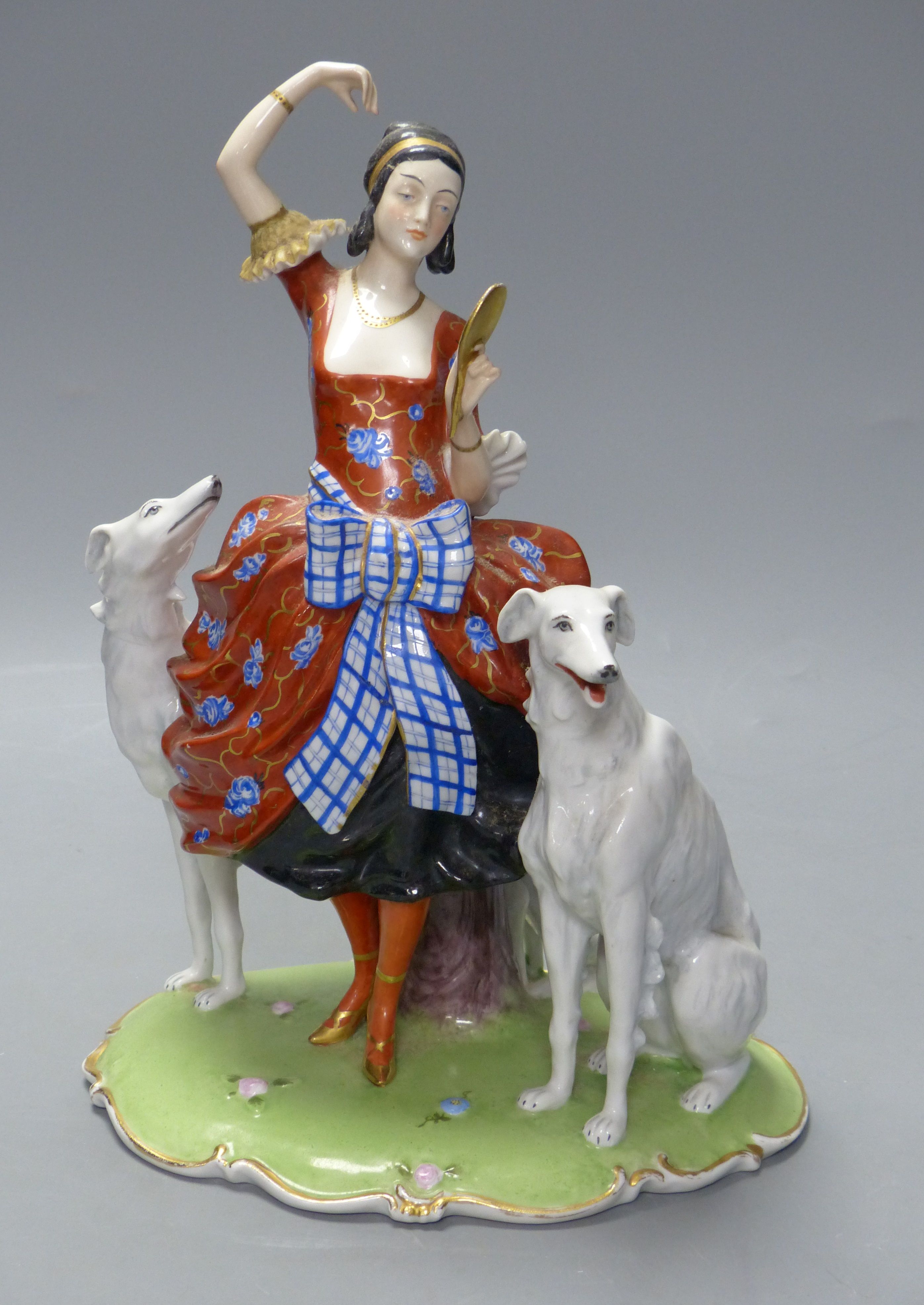 An Art Deco Fraureuth group modelled as a lady wearing a red gown flanked by two Borzoi dogs, H 28cm